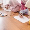 Muslim woman teaching her children painting and drawing at home.